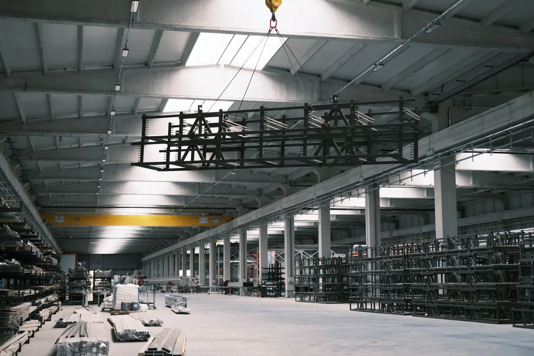 Large industrial warehouse interior with steel framing and overhead crane